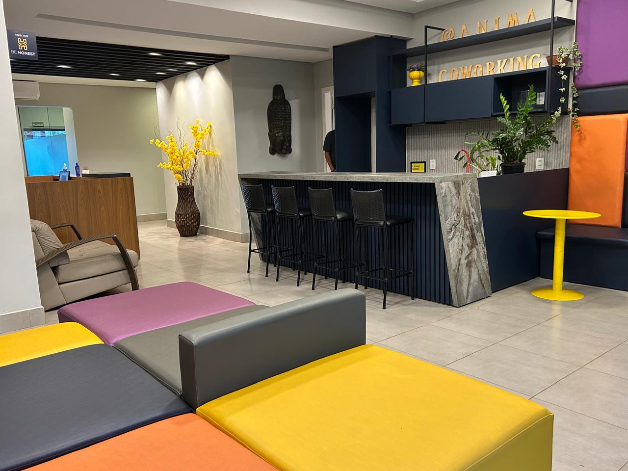 Área de convivência com bancada e sofás coloridos