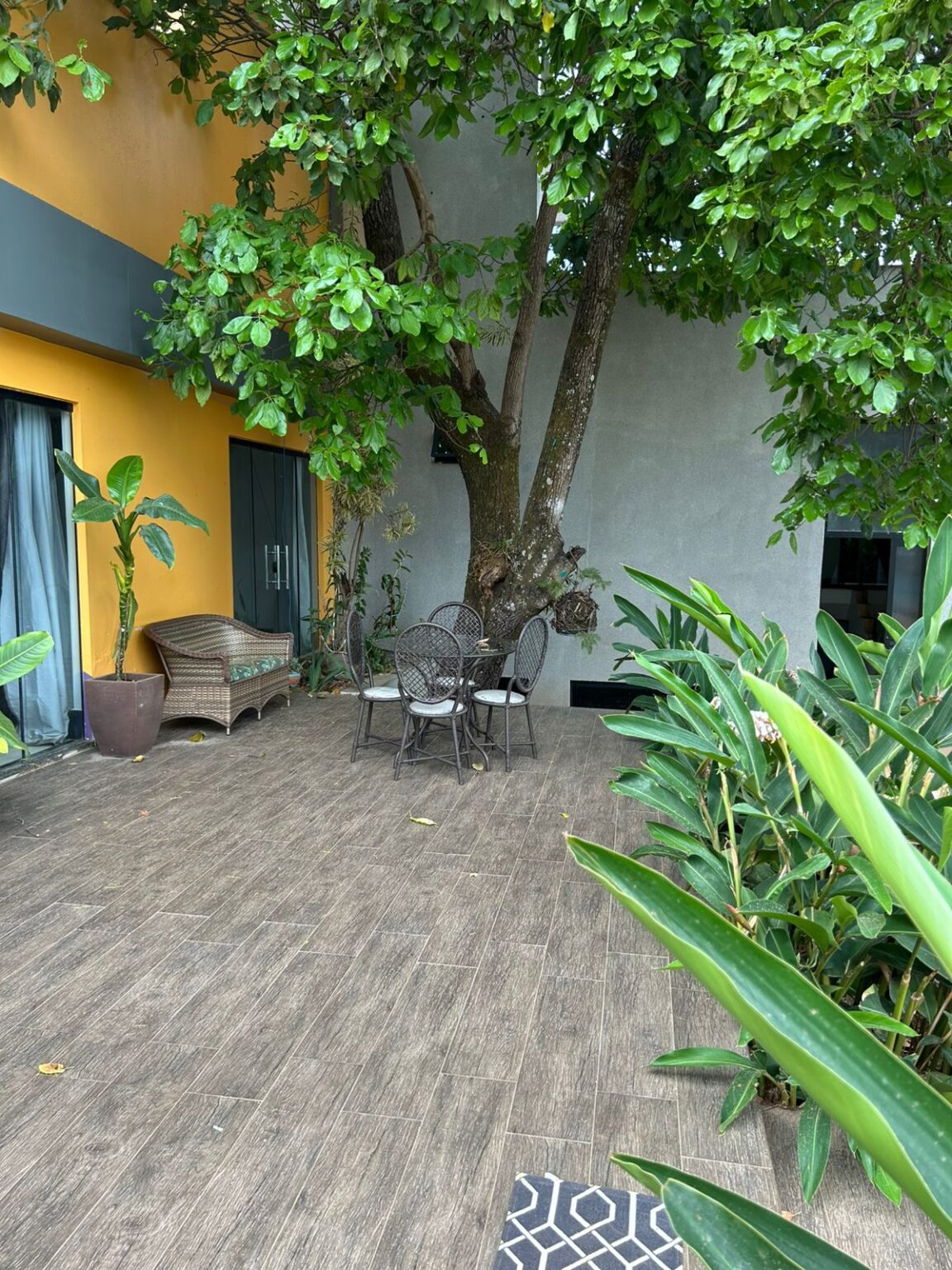 Jardim interno com árvore e mesas